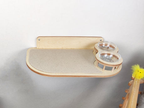 Wall mounted feeder with 2 raised bowls, light wood and light carpet. Bowls on the right side of the shelf.