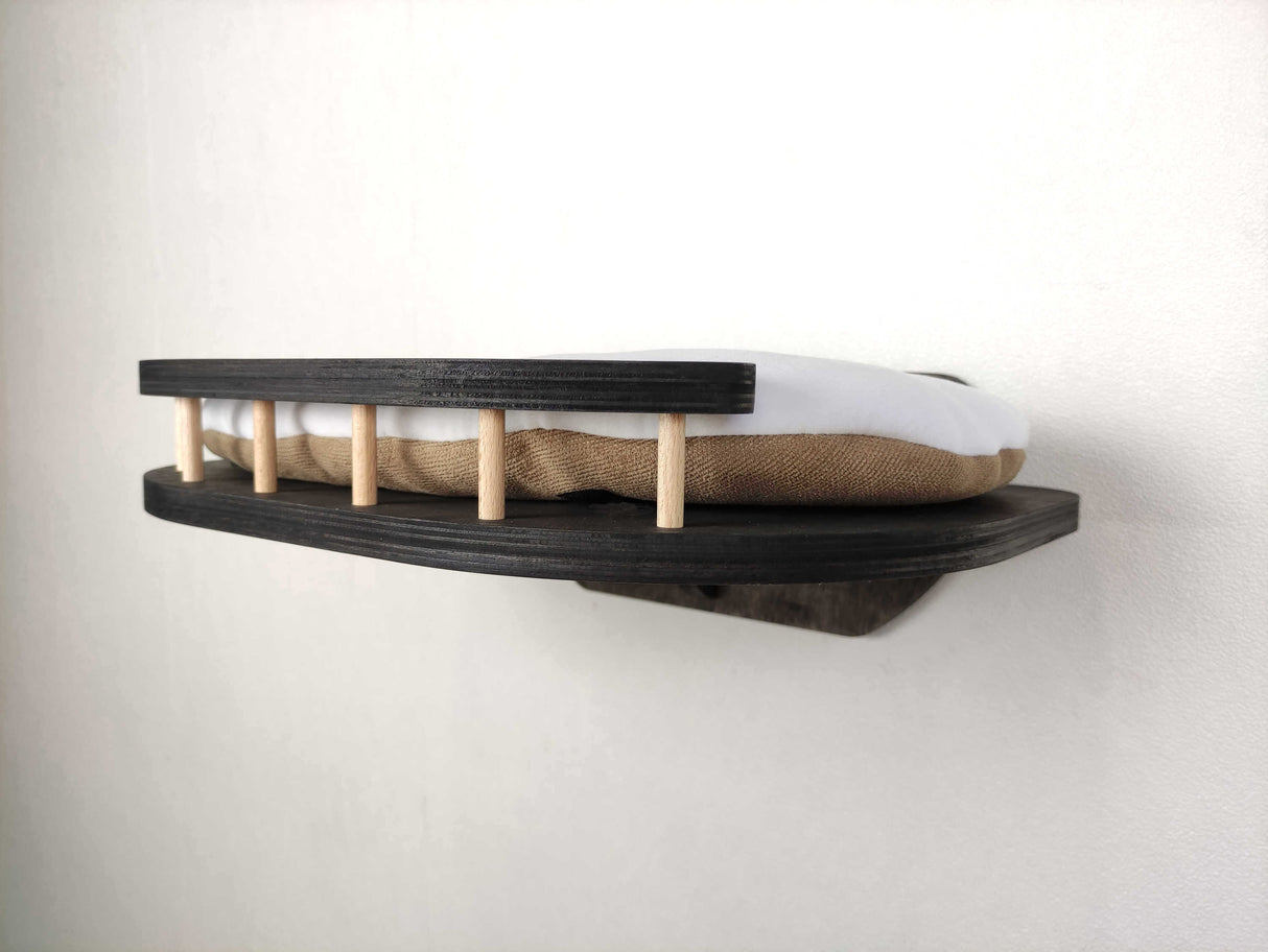 Wooden cat shelf with a mattress on a plain background