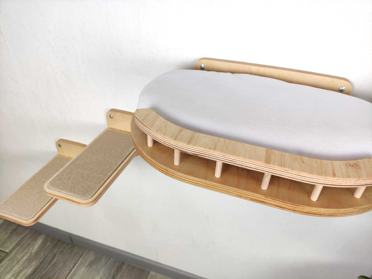 Wooden cat bed with a cushioned surface on a white background