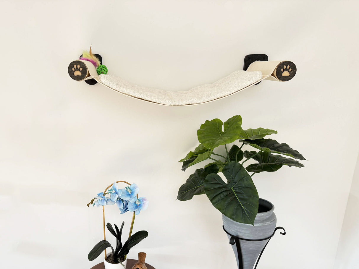 Cat wall shelf with plants and small figurines against a white wall