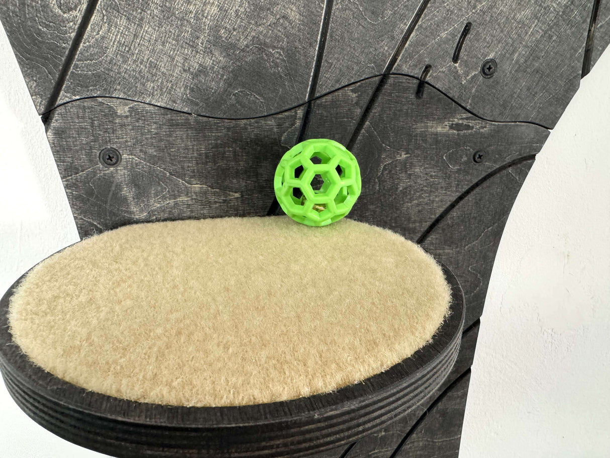 Green ball on a textured black and beige surface