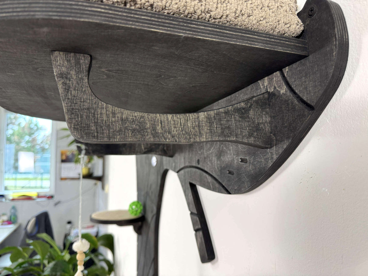 Wooden shelf bracket on a white wall with a blurred indoor background