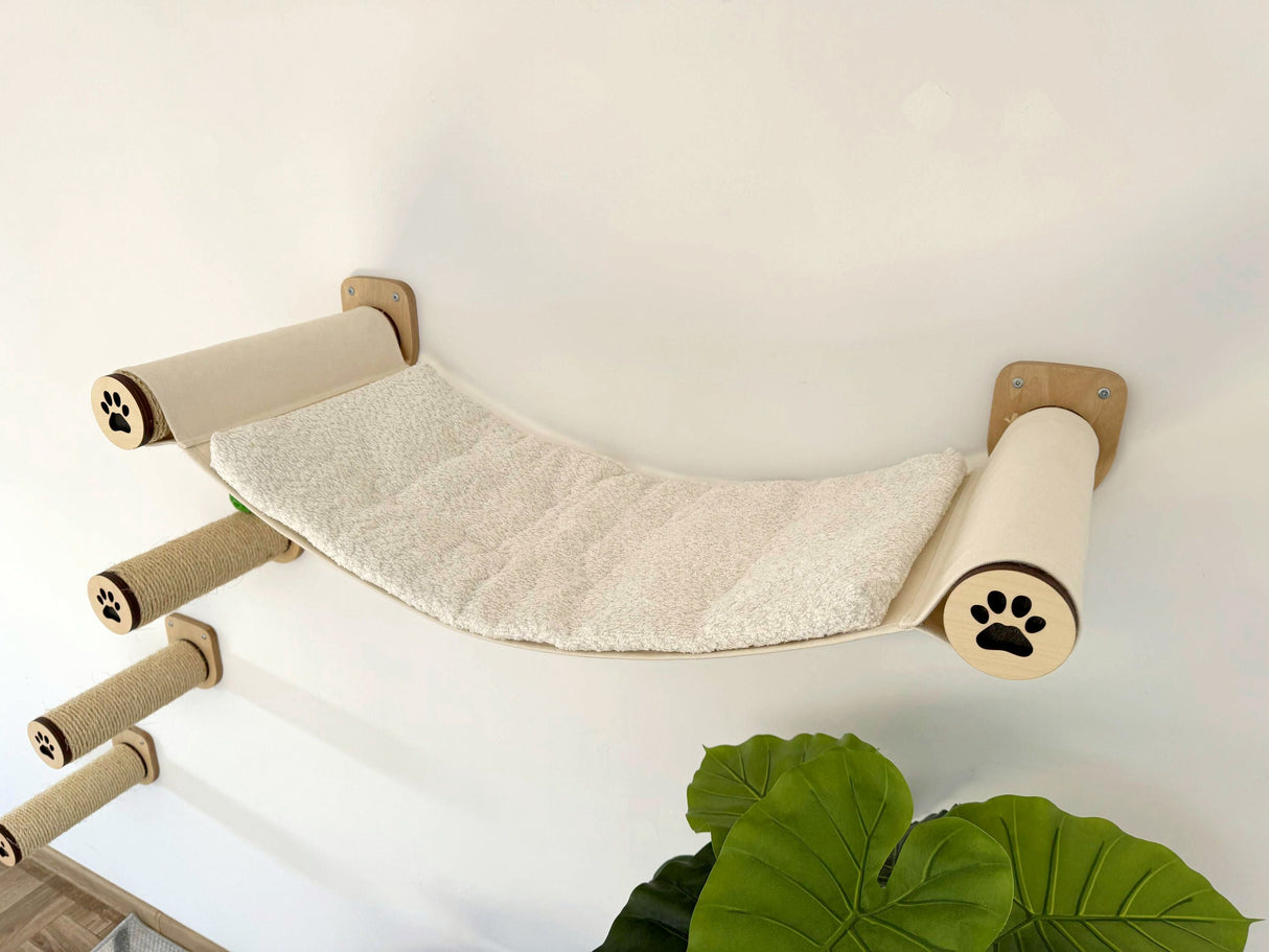Cat hammock with sisal steps attached to a wall, featuring paw prints.