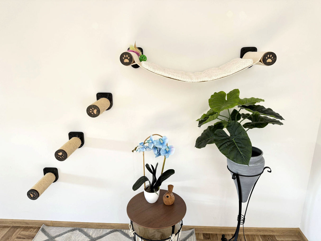 Cat climbing wall with various levels and a small table with plants on a wooden floor.