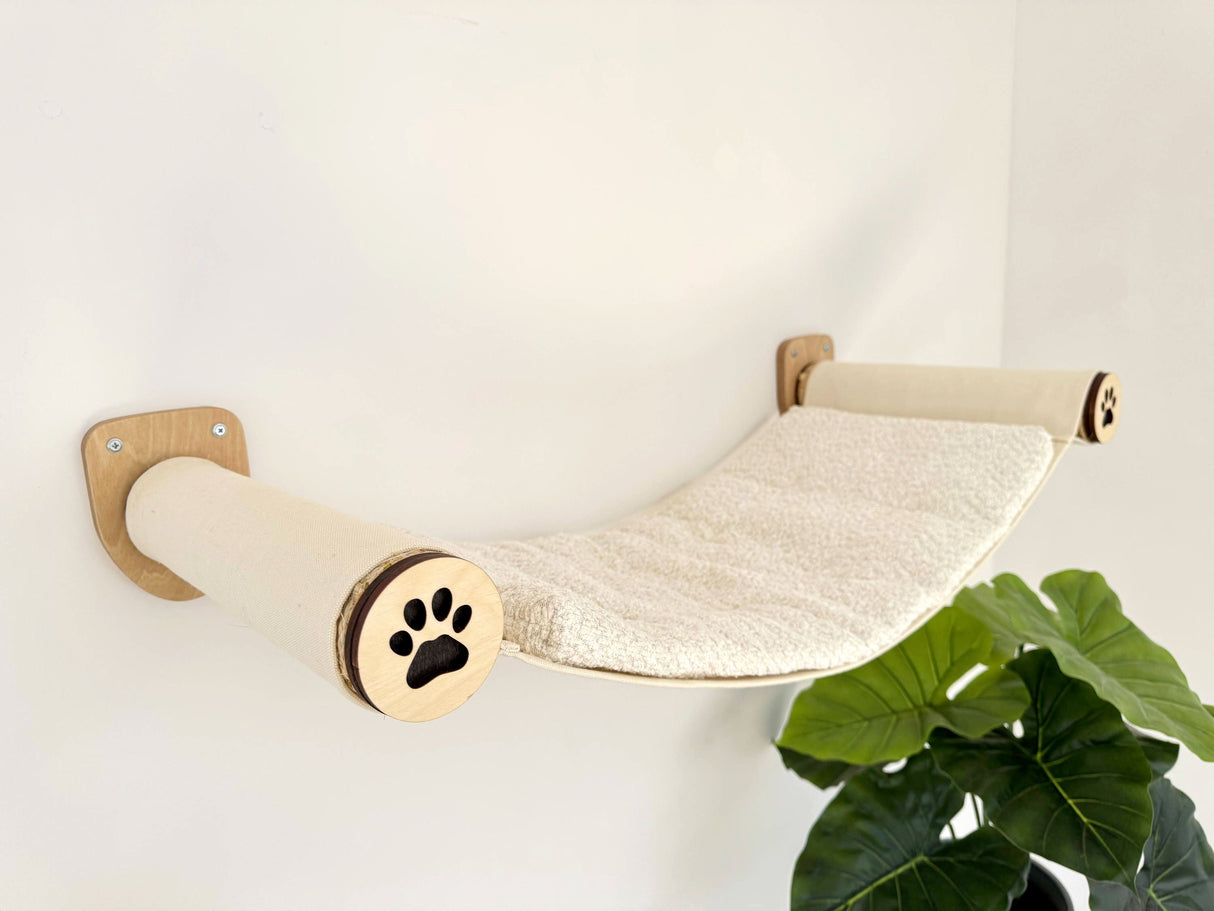 Wall-mounted cat shelf with a paw design on a white wall
