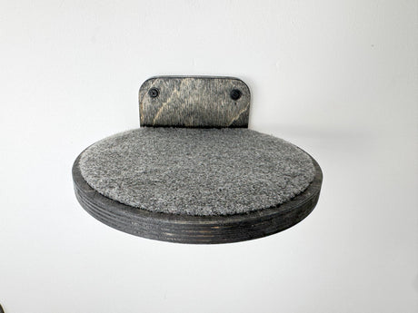 Dark wood round cat wall step with textured carpet, providing a stable climbing surface for felines