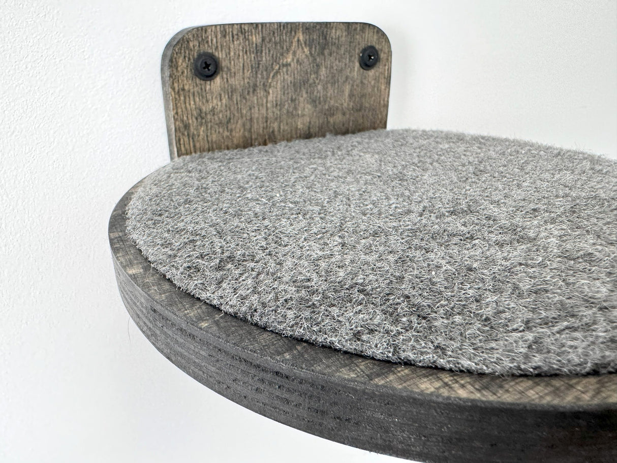 Wall-mounted cat climbing step, round shape with dark wood and a plush carpet insert for comfort