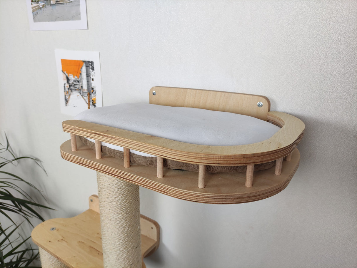 Wooden cat tree with a platform and scratching post against a white wall.