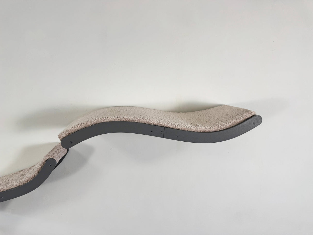 Curved pet bed with beige cushion on a white background