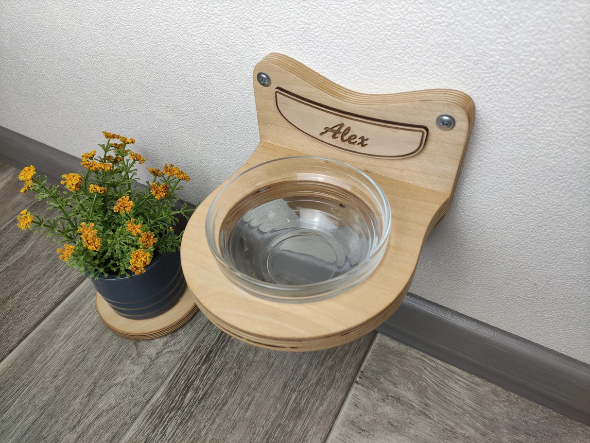 Compact wall-mounted feeder for cats in light wood with glass bowl