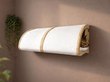 Wall-mounted cat bed with a cat inside on a beige wall.