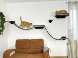 Cat climbing on a wall-mounted cat tree in a living room with a brown sofa and plant.