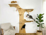 Wooden cat tree with multiple levels and cats on different platforms in a room.