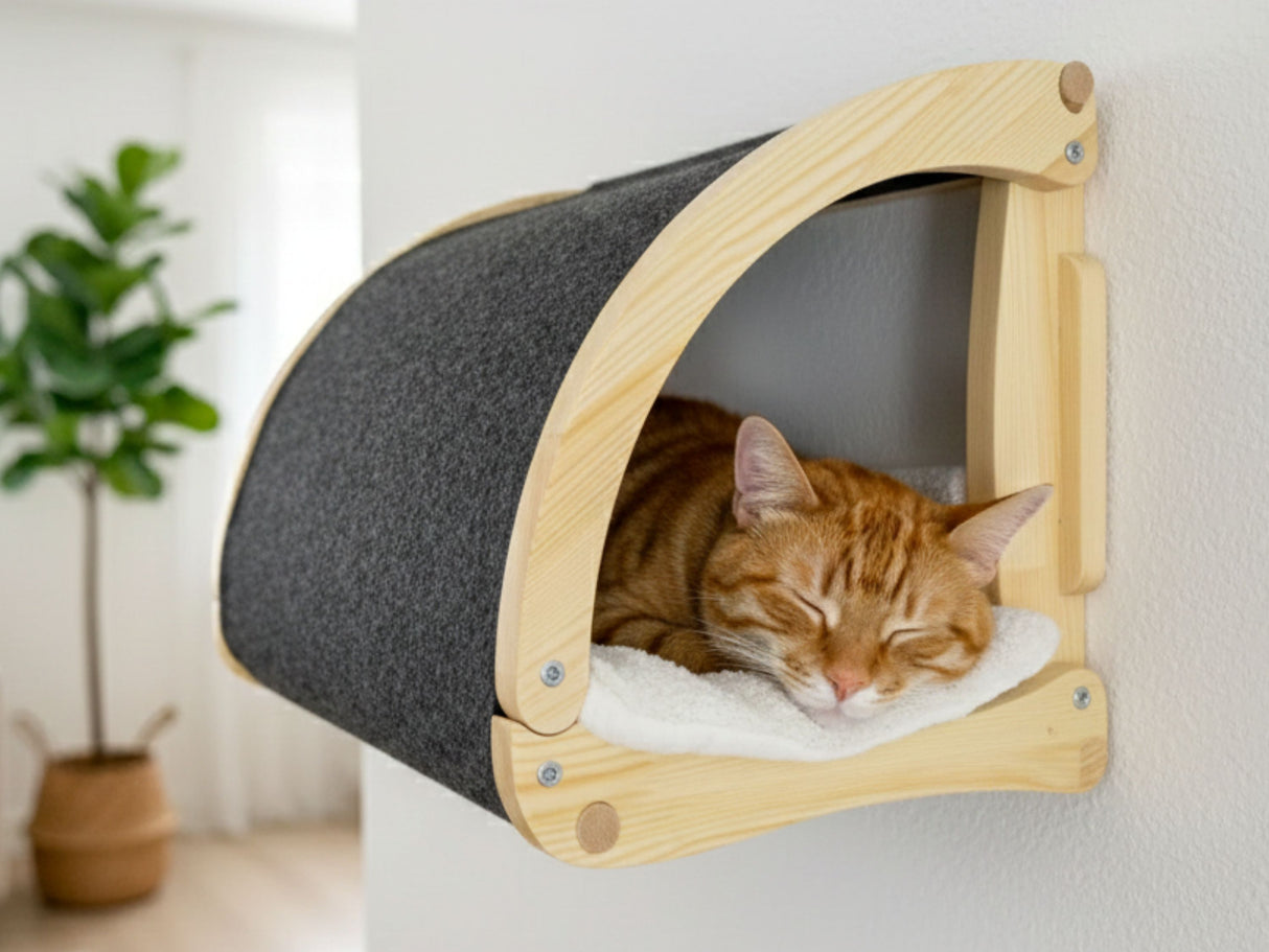 Cat resting in a wooden and gray pet bed attached to a wall.