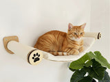 Cat lounging on a wall-mounted cat shelf with a paw print design.
