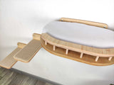 Wooden cat bed with a cushioned surface on a white background