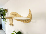 Wooden cat shelf with curved design on a white wall