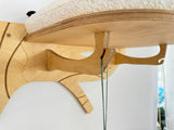 Wooden cat tree with a cushioned platform and perches on a white background