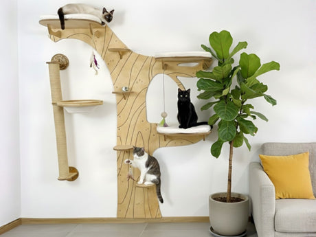 Cat tree with multiple levels and a cat sitting on a shelf in a room with a plant and sofa.