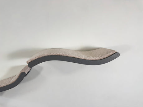 Curved pet bed with beige cushion on a white background