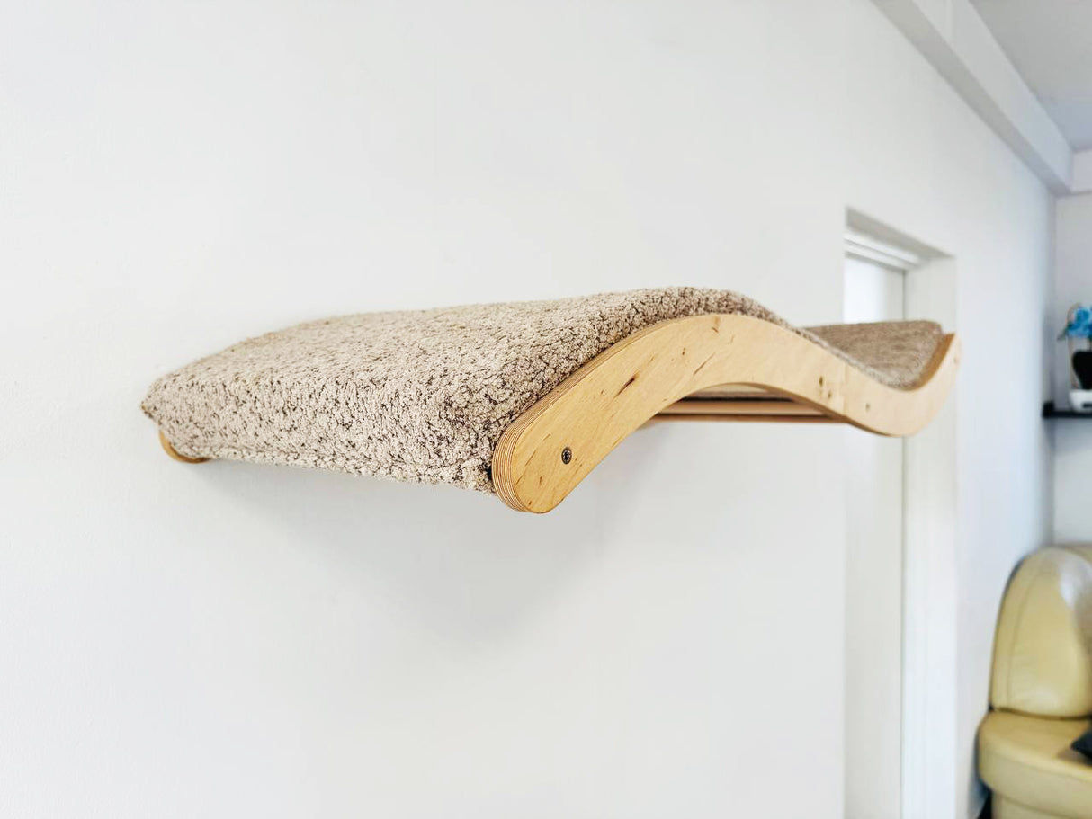 Wavy cat shelf mounted on a white wall