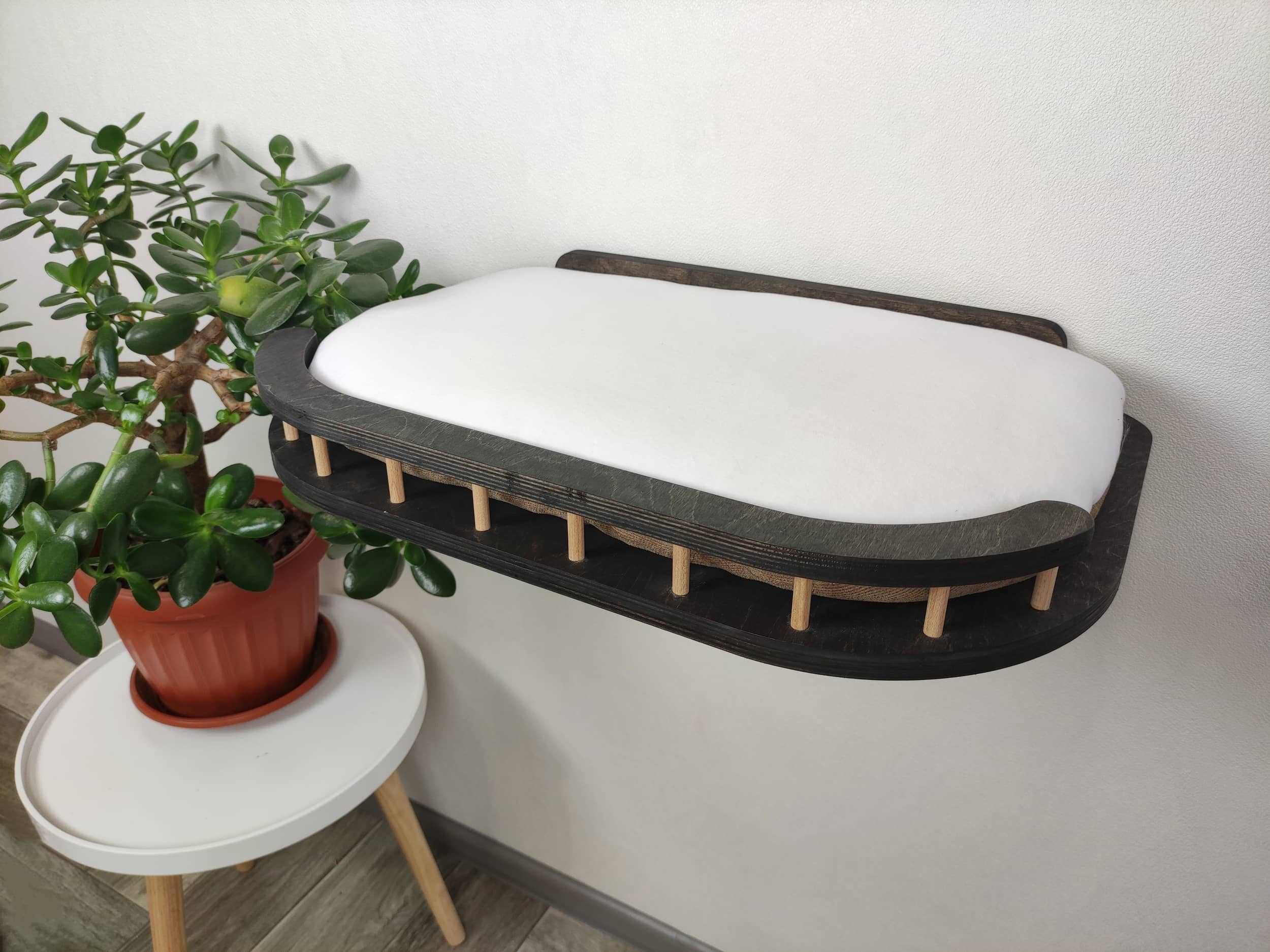 Cat wall bed in a dark colors of the wood and soft white pillow
